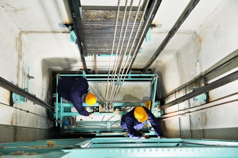Technician adjusting elevator mechanism